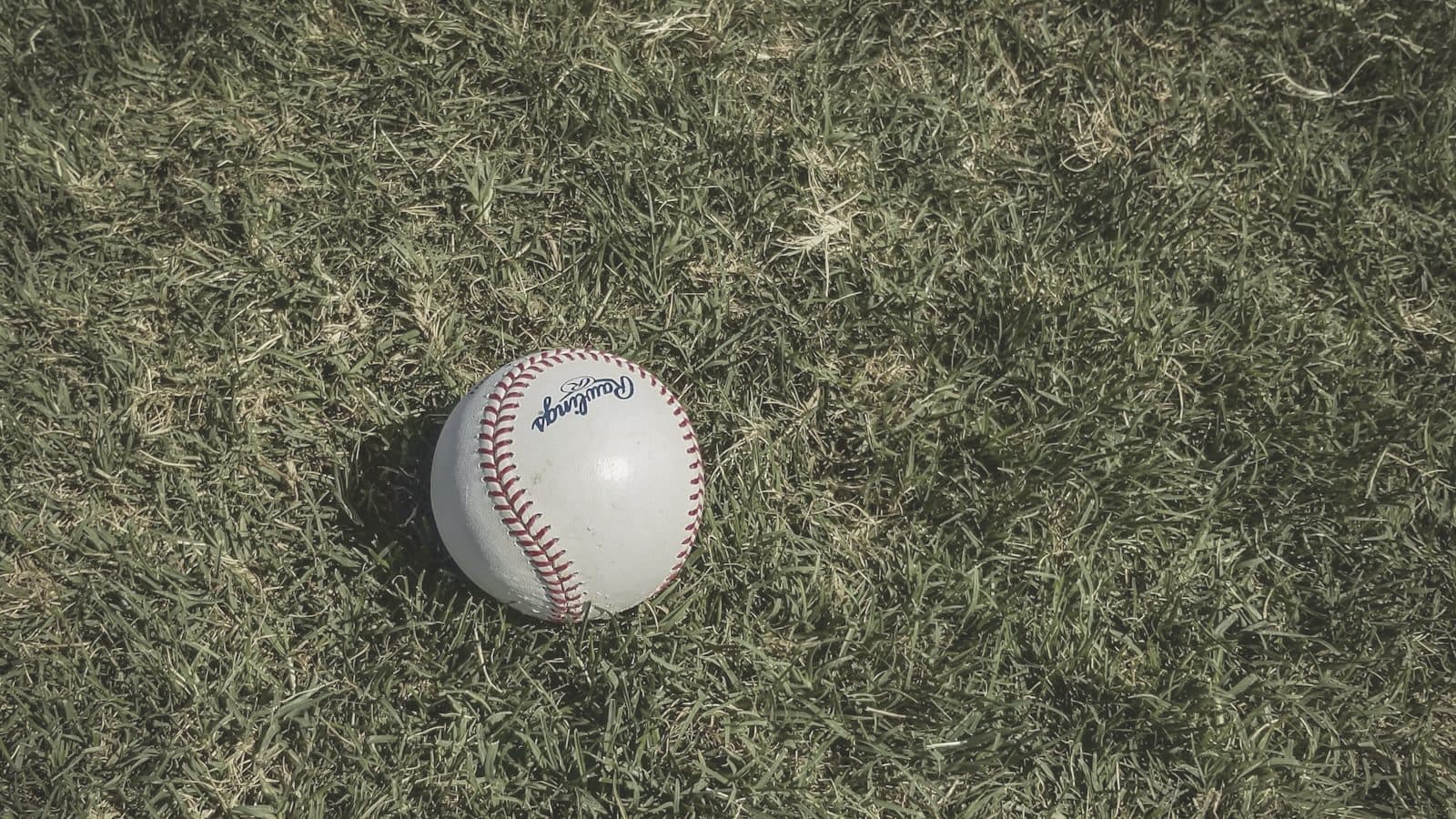 A baseball field viewed through backstop netting at dusk